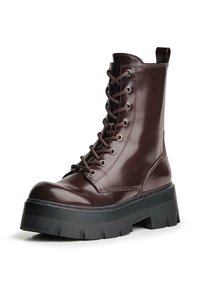 Botine din piele maro, cu șireturi, având gleznă înaltă, vârf rotunjit, talpă groasă neagră și detalii de cusătură proeminente.