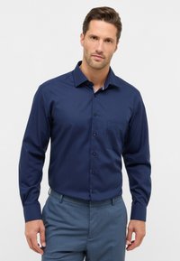 Marineblauwe longsleeve shirt met een button-down kraag, één borstzak en contrasterende details aan de binnenkraag; gladde textuur, zonder patronen.