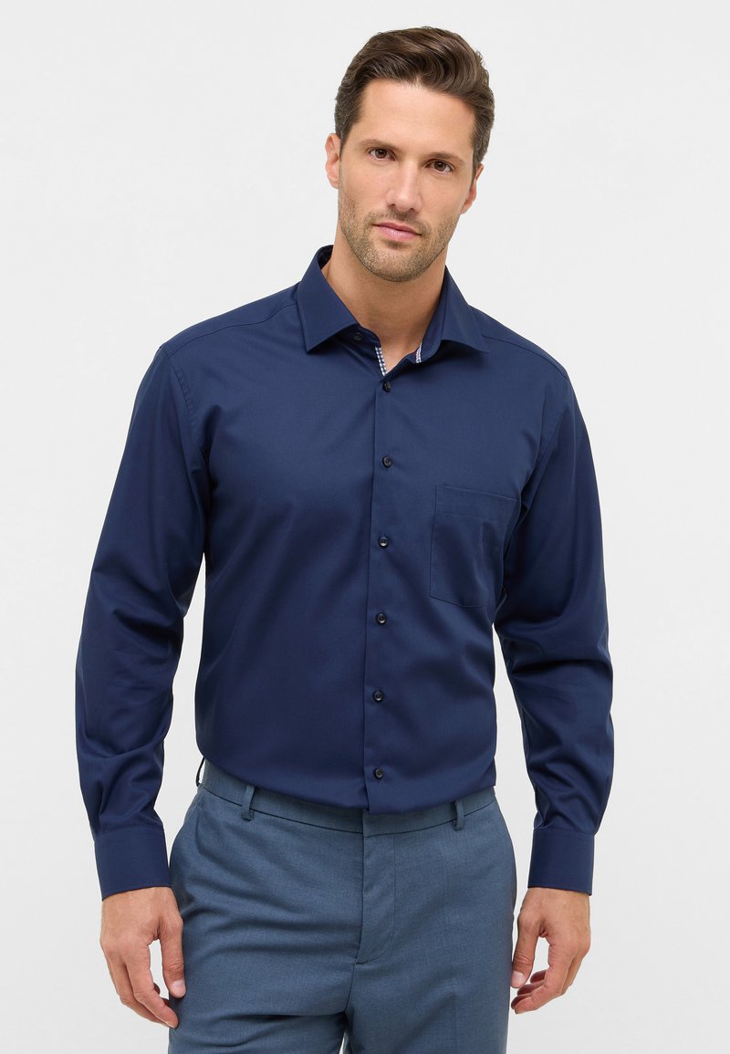Marineblauwe longsleeve shirt met een button-down kraag, één borstzak en contrasterende details aan de binnenkraag; gladde textuur, zonder patronen.