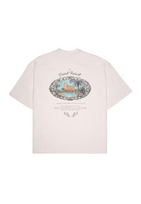 Light pink cotton t-shirt featuring a graphic of a resort with palm trees, surrounded by decorative black floral accents and text.