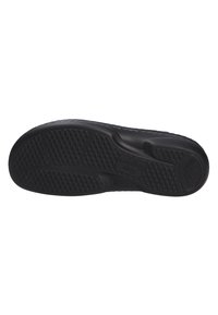 Sole di calzature nera con superficie in gomma testurizzata, caratterizzata da un motivo di punti e scanalature sollevati per aderenza e grip.