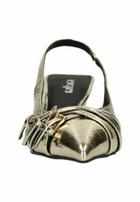 Chaussure plate en métal doré avec un bout pointu, ornée de bandes décoratives et d'une petite boucle. Semelle intérieure noire avec logo.