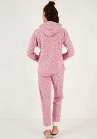 Conjunto de pijama rosa con capucha, con rayas verticales y pequeños patrones de estrellas, hecho de una tela suave. Puños forrados con un material blanco esponjoso.
