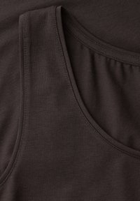 Canotta senza maniche marrone scuro realizzata in tessuto morbido e liscio con cuciture visibili lungo i bordi dell'ascella e dello scollo.