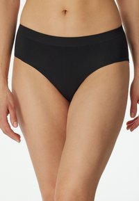 Svart bikini-undertøy laget av et elastisk, glatt materiale med en bred elastisk midjebånd, uten synlige sømmer eller mønster.