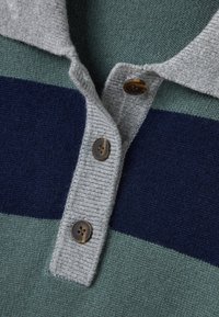 Polo gris con cuello y Rayas horizontales en azul marino, verde y teal. Presenta botones marrones y textura de cuello y tapeta acanalada.