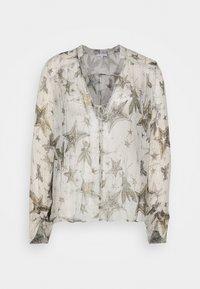 Durchsichtige Bluse mit V-Ausschnitt, die ein Sternmuster in Silber und Gold auf weißem Hintergrund zeigt. Leichter Stoff mit langen Ärmeln und Bindeband.