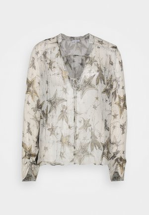 Transparante blouse met V-hals, versierd met een sterpatroon in zilver en goud op een witte achtergrond. Lichte stof met lange mouwen en een strikdetail.