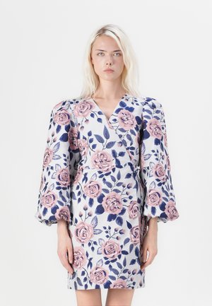 Vestido envolvente floral com base branca, grandes rosas cor-de-rosa e folhas azul-marinho. Mangas ousadas e bufantes e detalhe de laço na cintura. Textura suave.
