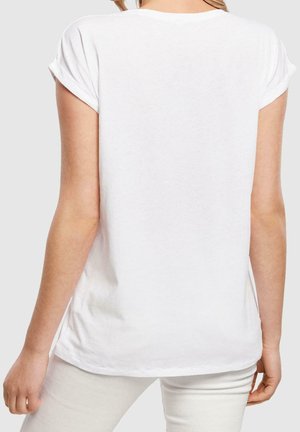 T-shirt bianco a maniche corte con scollatura rotonda. Tessuto di cotone morbido, vestibilità comoda e maniche arrotolate. Dettagli di cucitura sottile.