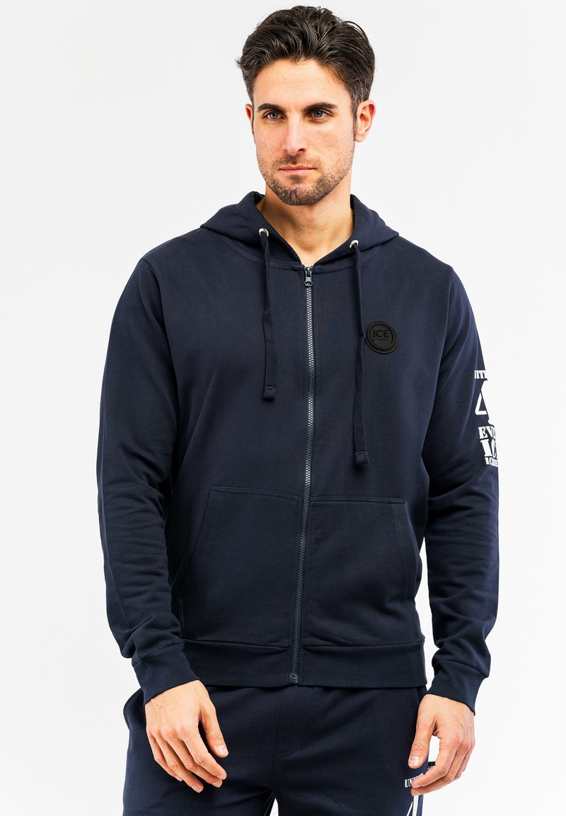 Mornarska zip-up dukserica od mješavine pamuka s prednjim džepom, podesivom kapuljačom s vezicom i logotipom na prsima i rukavu.