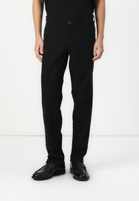 Pantalones de algodón negros con corte recto, con cierre de botón, trabillas para cinturón y bolsillos laterales; textura suave y detalles mínimos.