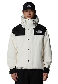 White jacket with black accents, high collar, adjustable hood, and front snap buttons. Logo displayed on left chest and hat.