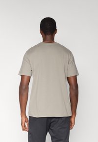 Κοντομάνικο μπλουζάκι με στρογγυλή λαιμόκοψη από ανοιχτό γκρι βαμβάκι. Διαθέτει άνετη εφαρμογή και επίπεδες ραφές. Μινιμαλιστικός σχεδιασμός χωρίς ορατά λογότυπα.