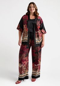 Black satin outfit featuring a floral pattern in red and gold, with a kimono-style top and wide-leg pants, accented with striped details.