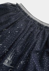 Gonna di tulle blu navy con stampa di stelle argentate e castelli, dotata di una vita elastica e di una texture trasparente.