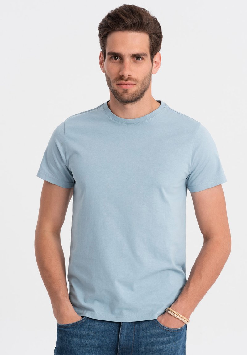Lyseblå kortærmet t-shirt i glat bomuldsstof, med rund halsudskæring og en afslappet pasform, parret med denim jeans.