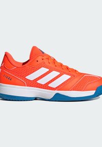 Adidas Ligra-kengät, joissa on kirkkaan oranssi verkko-osa valkoisilla raidoilla, pehmustettu nilkkareuna ja sininen kumipohja. Kevyt malli.