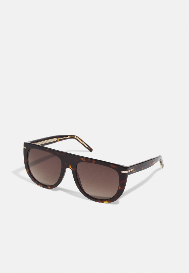 Sonnenbrille mit einem Schildpatt-Rahmen, dunklen Verlaufsgläsern und eleganten goldenen Akzenten an den Bügeln. Quadratische Form, robustes Design.