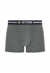 Boxer-briefs gris foncé en tissu doux et extensible. Présente une taille noire avec un logo blanc et des accents horizontaux.