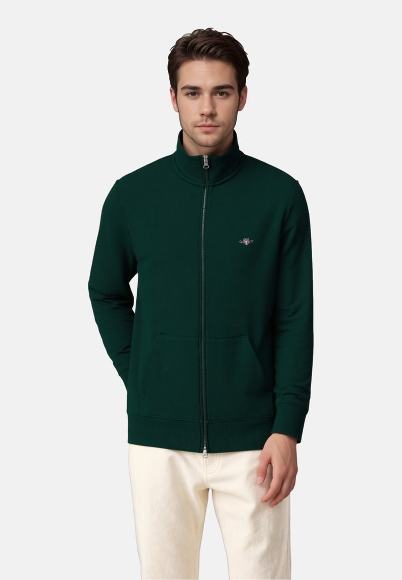 Reißverschluss-Sweatshirt aus dunkelgrünem Baumwoll-Mix mit hohem Kragen, gerippten Bündchen und Saum sowie einem kleinen Logo auf der Brust.