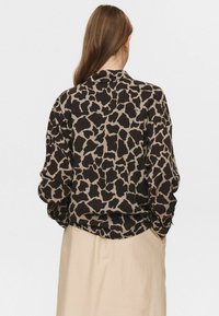 Košulja dugih rukava, smeđa i bež sa uzorkom, koja se ističe dizajnom prints giraffe, s ležernim krojem i jednostavnom kragnom.
