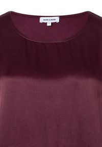 Burgundy short-sleeve top with a round neckline, smooth texture, and subtle sheen. Label shows brand "MORE & MORE" and size 36.
