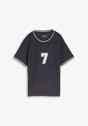 Schwarzes oversized T-Shirt mit kurzen Ärmeln und weißem Besatz am Kragen und an den Ärmeln, mit großer weißer Nummer 7 auf der Vorderseite.
