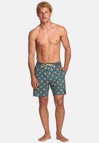 Costumi da bagno da uomo in teal con un motivo di stelle arancione su tutta la superficie. Presentano una vita elastica grigia con cordoncino e tasche laterali.