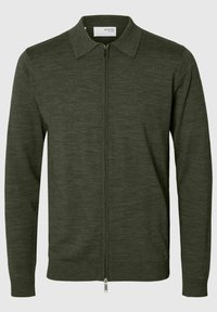 Tamsiai žalia užtrauktuku užsegama kardiganas, pagamintas iš minkštos, tekstūruotos medžiagos. Yra apykaklė ir gumbiniai rankogaliai ant rankovių bei apatinio krašto.