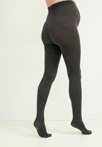 Dunkelgraue, gemusterte Strumpfhosen mit gerippter Textur, die ein geometrisches Diamantdesign an den Unterschenkeln und einen hohen Bund aufweisen.