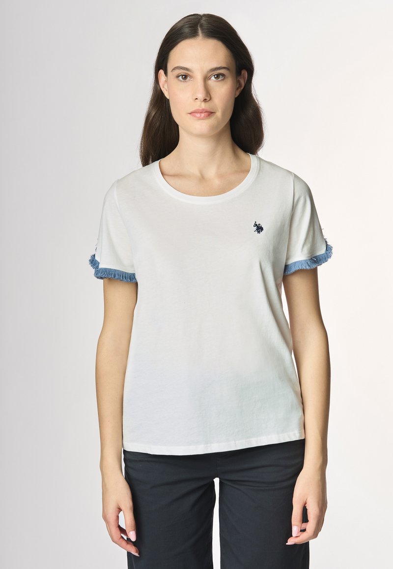 T-shirt bianca in cotone con colletto rotondo, maniche corte con frange azzurro chiaro e un piccolo logo ricamato sul petto.