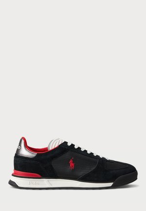 Baskets basses noires avec lacets blancs, doublure intérieure rouge, logo Polo rouge sur le côté, détail au talon argenté, et semelle blanche avec semelle extérieure noire.