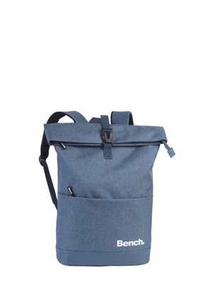 Sac à dos bleu avec rabat enroulable, poche avant, boucle noire, bretelles réglables et logo "Bench." sur le bas devant.