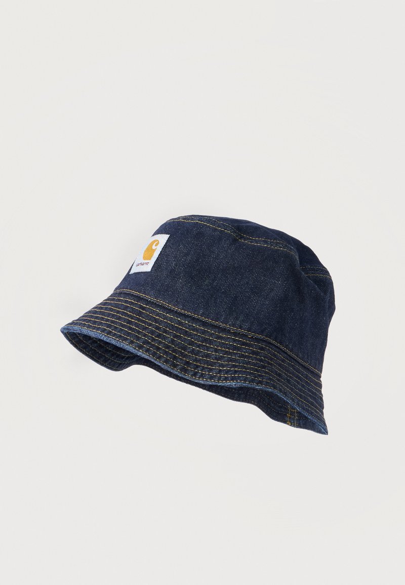 Σκούρο μπλε ψάθινο καπέλο από τζιν με κίτρινη αντίθεση ραφής και τετράγωνη λευκή ετικέτα με κίτρινο λογότυπο στη μπροστινή όψη.