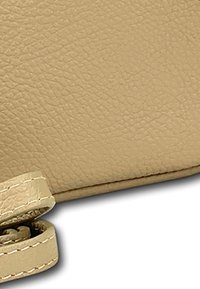 Beige leren portemonnee met een gestructureerde oppervlakte. Heeft een opgerolde riem, nette stiksels en een gladde rand.