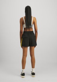 adidas Sportswear ESSENTIALS 3 STRIPES LIFESTYLE - Sporta šorti - black/hazy yellow