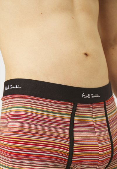 Boxer-briefs pour hommes à rayures dans un mélange de rouge, jaune et vert, avec une taille noire arborant le logo "Paul Smith" brodé en blanc.