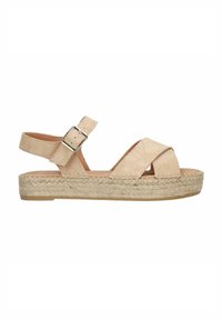 Beige suède sandaal met kruislings straps, verstelbare gesp en een geweven juten plateauzool. Platte hak en textuurovervlak.
