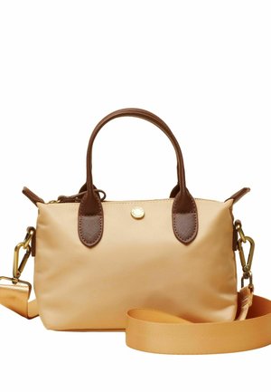 Kleine beigefarbene Handtasche mit dunkelbraunen Griffen und abnehmbarem breitem Gurt, goldfarbenen Beschlägen und einer runden Logo-Schaltfläche auf der Vorderseite.