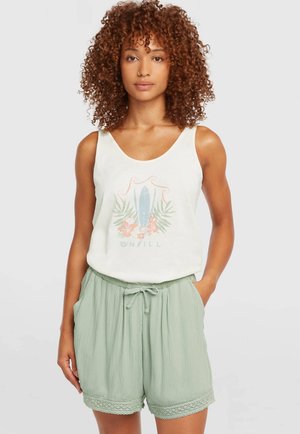 Camiseta blanca sin mangas con estampado colorido de tabla de surf y flores, combinada con pantalones cortos verdes claros con textura, ribete de encaje y cintura con cordón.