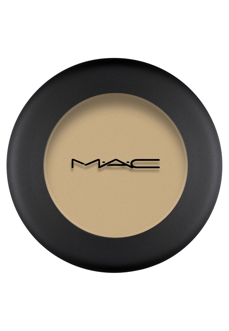 Zwarte ronde compact met een getextureerde beige poeder. Het MAC-logo is prominent in zwart op het oppervlak weergegeven.