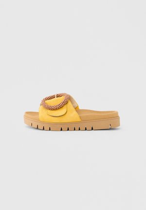 Gul åben-tå slide sandal med en tekstureret sål og en rem dekoreret med runde beige perler.