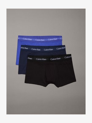 Τρία ζευγάρια ανδρικών εσωρούχων: ένα ανοιχτό μπλε, ένα σκούρο μπλε και ένα μαύρο. Το καθένα έχει λογότυπο στη μέση με το "Calvin Klein" σε λευκό χρώμα.