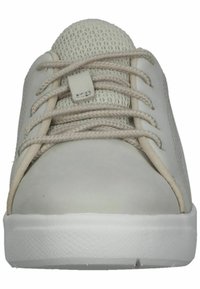 Ljusgrå sneaker med en slät läderkropp och en texturerad mesh-tunga, med beige snören och en vit gummisula.