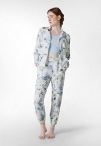 Lightweight, floral-patterned tracksuit in shades of blue and white. Jacket has a zip front and stand collar. Pants feature elastic cuffs and pockets.