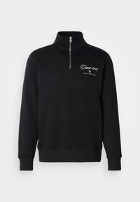 Čierna mikina s krátkým zipsom a dlhými rukávmi, s rebrovanými manžetami a logom "Gant 1949 American Sportswear" na ľavej strane hrudi.