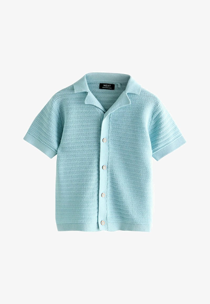 Camisa azul claro de manga corta hecha de tela de punto texturizada. Frente abotonado con pequeños botones redondos y diseño de cuello plano.