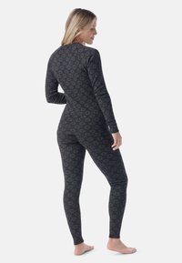 Long-sleeve thermal bodysuit in black with a geometric pattern. Made of soft fabric, features a fitted design and seamless legs.
