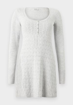 Vestido suéter de manga larga color gris claro con dobladillo acanalado y diseño de punto con trenzas texturizadas. Presenta un escote redondo y cierre frontal con botones.